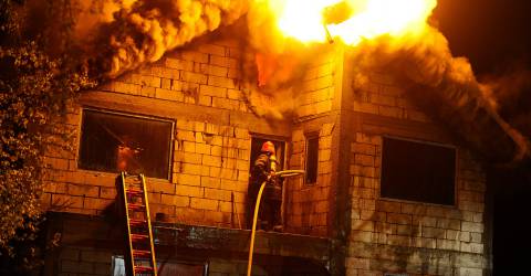 Brandweer blust een huis wat in brand staat