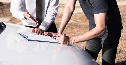 Verzekeringsagent en de eigenaar van de auto tekenen de overeenkomst voor een schadeclaim